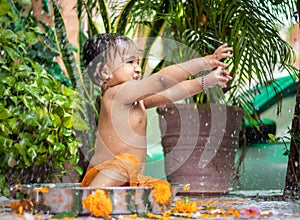 cute toddler baby boy bathing in decorated bathtub at outdoor from unique perspective