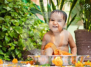 cute toddler baby boy bathing in decorated bathtub at outdoor from unique perspective