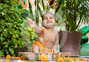 cute toddler baby boy bathing in decorated bathtub at outdoor from unique perspective