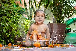 cute toddler baby boy bathing in decorated bathtub at outdoor from unique perspective