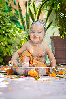 cute toddler baby boy bathing with shampoo in decorated bathtub at outdoor from unique perspective