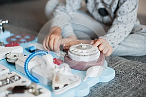 Cute toddler baby playing with busy board at home