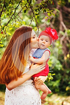 Cute Toddler Baby sitting on Mom`s Hands