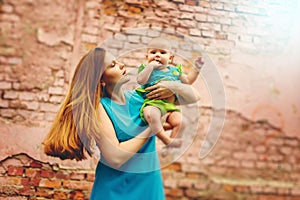 Cute Toddler Baby sitting on Mom`s Hands