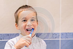 Cute toddler boy brushing his teeth in the bathroom. Kid learning how to stay healthy. Health care concept.