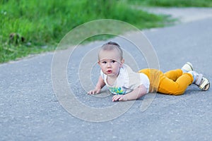 Cute toddler boy fell on park road