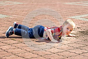 Cute toddler boy fell on park road