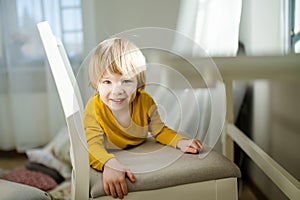 Cute toddler boy having fun at home. Child spending time in a cozy living room