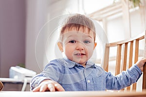 the cute toddler boy is sitting at the table