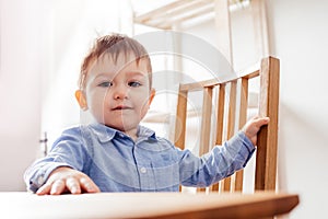 the cute toddler boy is sitting at the table