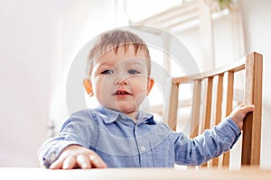 the cute toddler boy is sitting at the table