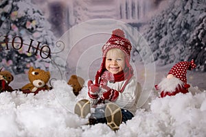 Cute toddler boy with winter outfit, playing in the snow, christmas shot