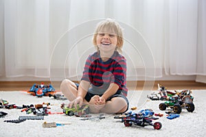Cute toddler child, blond boy, playing with colofrul plastic blocks, construction toys