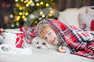 Cute toddler child, boy in a Christmas outfit, playing in a wooden cabin on Christmas, decoration around him