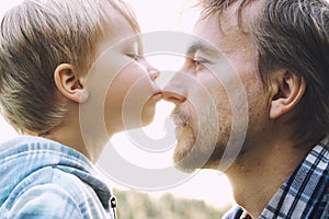 Cute toddler child boy kisses his father on nose. Tenderness, dad-son relationship, fathers day concept. Happy family moments