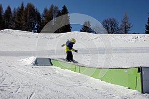 Cute toddler child in colorful ski wear, skiing in Italy on a sunny day, kids and adults skiing together