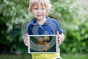 Cute toddler child, holding a picture of his little unborn baby sister