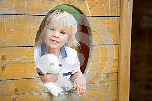 Cute toddler child with white maltese puppy, playing in the park, walking