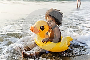 Cute toddler with duck tube on the beach