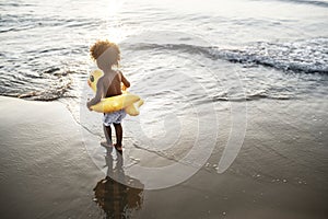 Cute toddler with duck tube on the beach