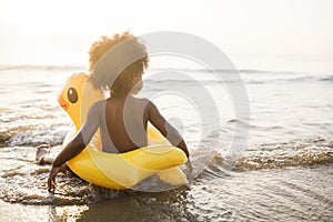 Cute toddler with duck tube on the beach