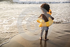 Cute toddler with duck tube on the beach