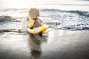 Cute toddler with duck tube on the beach