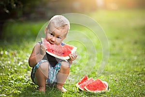 Cute toddler eating a slice of watermelon