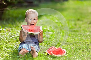 Cute toddler eating a slice of watermelon