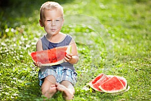 Cute toddler eating a slice of watermelon