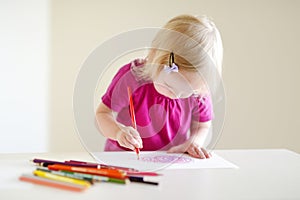 Cute toddler girl drawing with colorful pencils