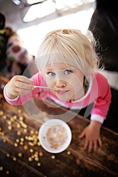 Cute Toddler Girl Eating Breakfast Cereal on a Sunny Morning