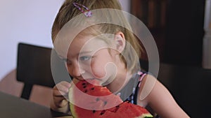 Cute toddler girl eating watermelon.