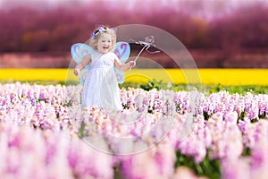 Cute toddler girl in fairy costume in a flower fie