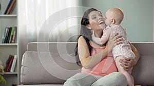 Cute toddler girl kissing and hugging her mother, love and tenderness in family