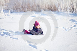 Little cute toddler girl outdoors on a sunny winter day.