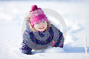 Little cute toddler girl outdoors on a sunny winter day.