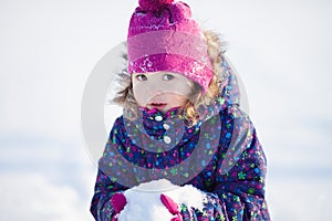 Little cute toddler girl outdoors on a sunny winter day.