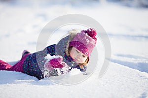 Little cute toddler girl outdoors on a sunny winter day.