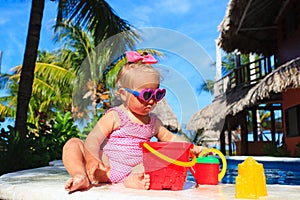 Cute toddler girl playing in swimming pool at the