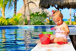 Cute toddler girl playing in swimming pool at