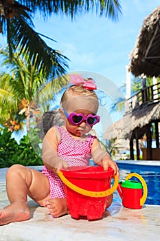 Cute toddler girl playing in swimming pool at the