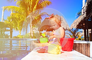 Cute toddler girl playing in swimming pool at