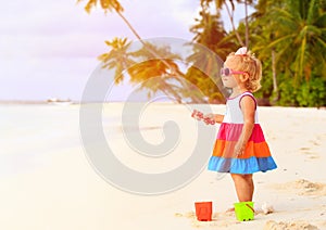Cute toddler girl playing with toys on tropical