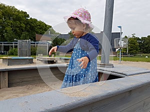 Cute toddler with pink hat and blue dress