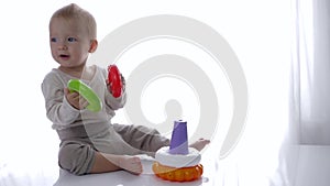 Cute toddler played educational toys pyramid in bright room