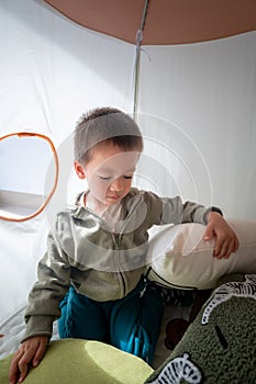 Cute toddler is playing in a kids tent at home