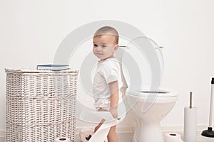 Cute toddler playing with toilet paper