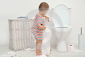 Cute toddler playing with toilet paper