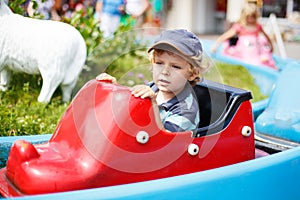 Cute toddler playing with water by the outdoor swimming pool